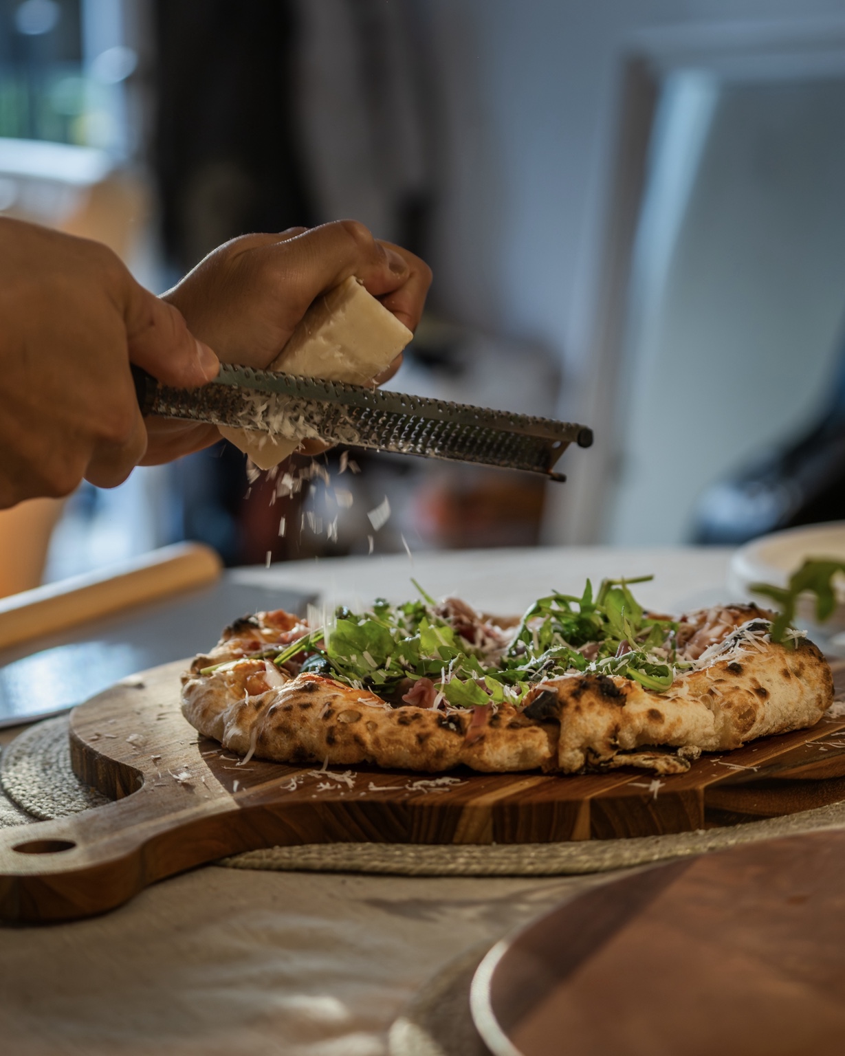 Parmesan râpé à la minute sur une pizza Rafa